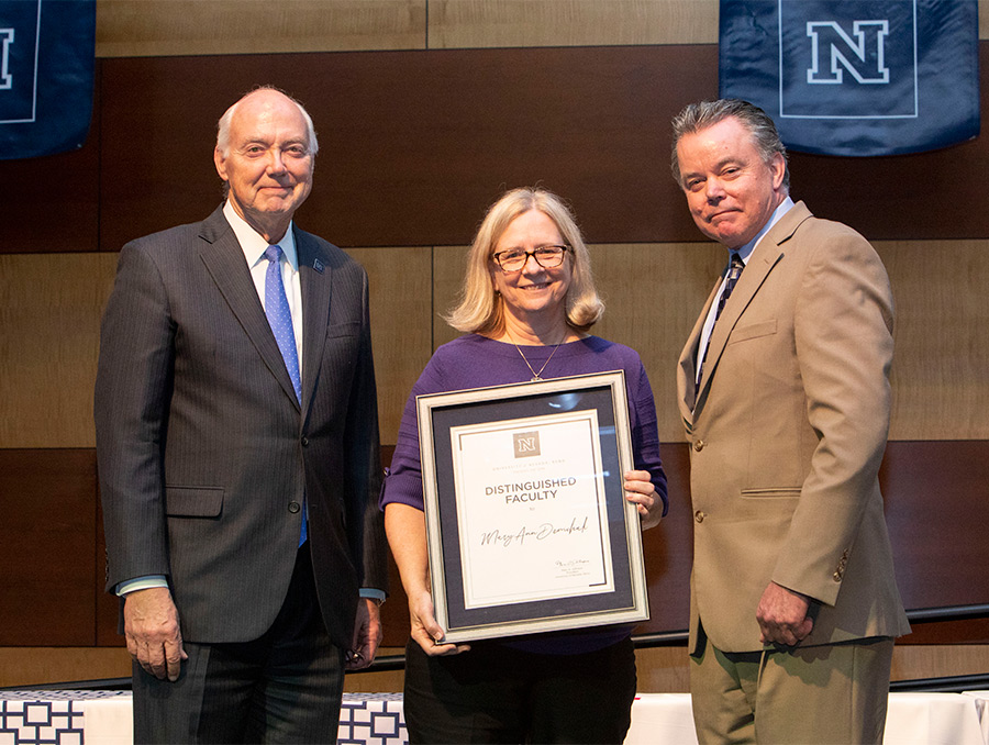 President Marc Johnson and Provost Kevin Carmen with MaryAnn Demchak, who is holding an award