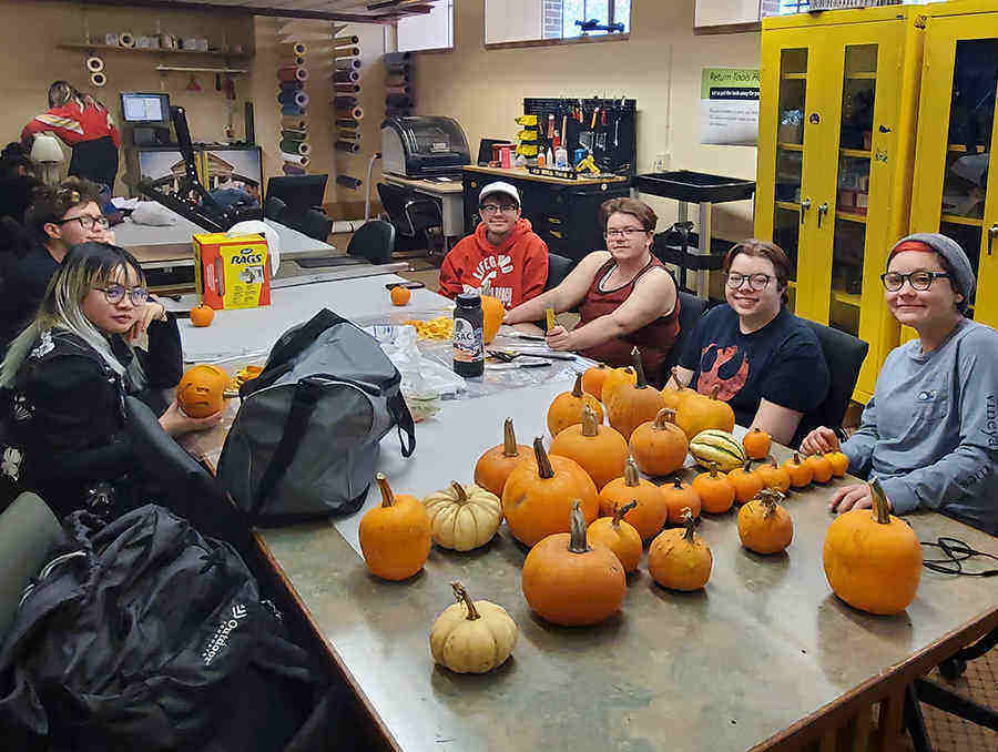 members of QSU sitting at a table with pumpkins on it