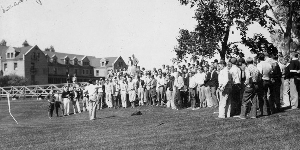 A group of students sing together in the Manzanita Bowl as part of Homecoming activities with the caption on the image reading, "Martin Leading Singing." (1929)