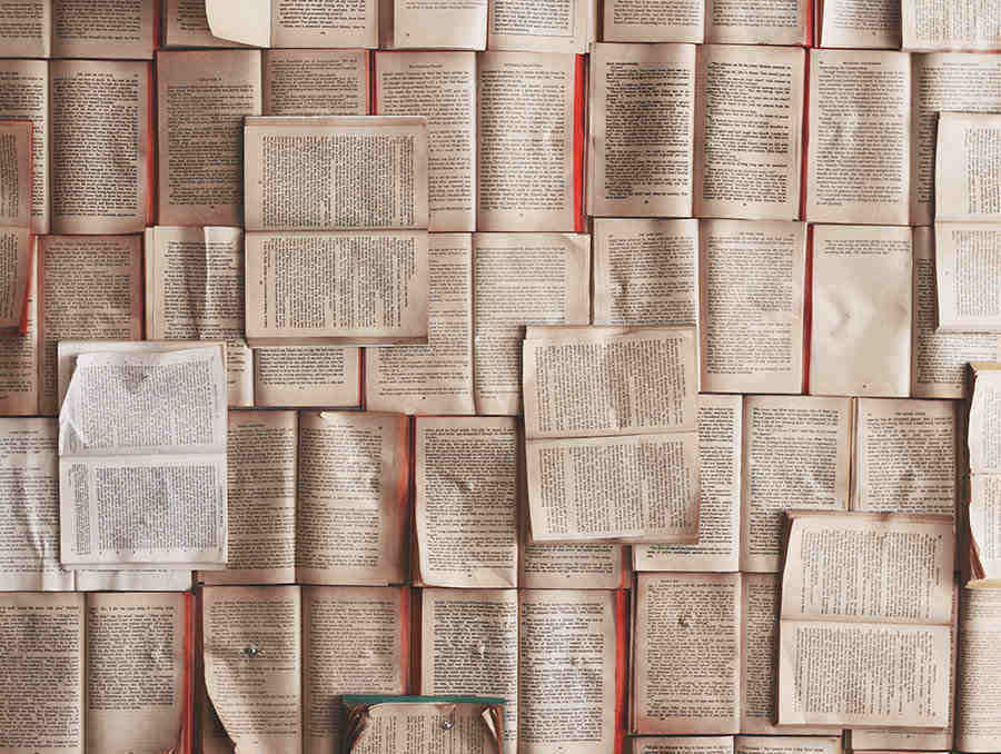 Image of many open books laid across a large table