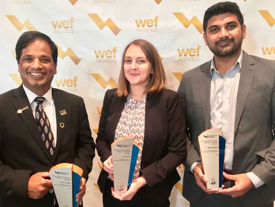 Researchers Dr. Krishna Pagilla, Laura Haak and Vijay Sundaram standing, smiling and holding up awards.