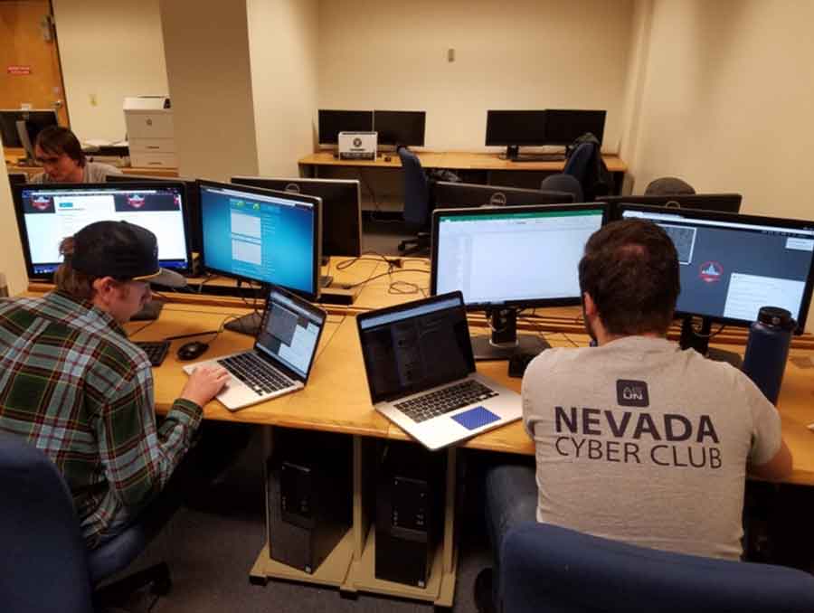 Two students practicing cyber drills in a computer lab. 