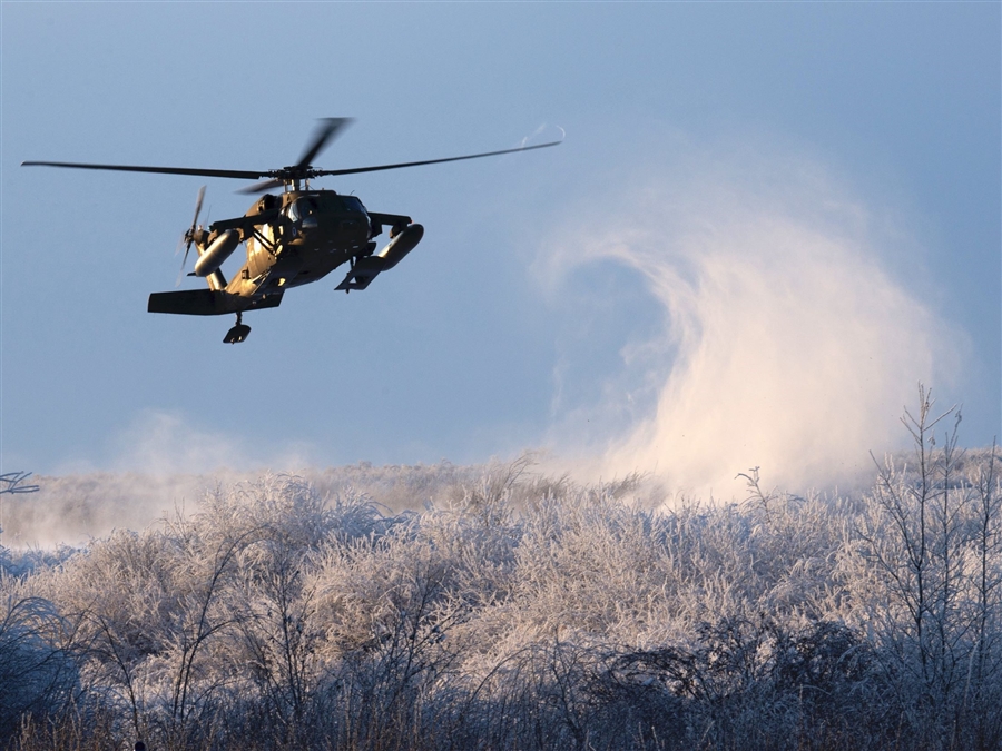 Alaska National Guard Black Hawk helicopter lands in snowy field.