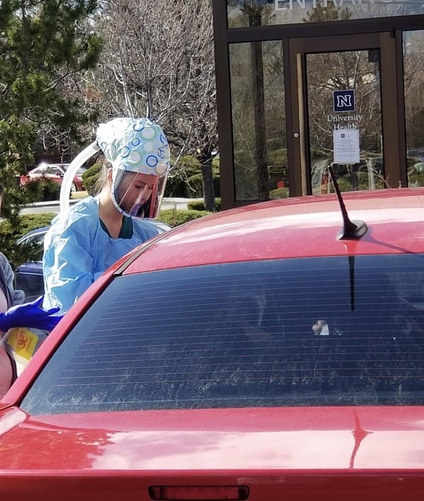 A UNR Med student in full protective gear participating in car testing