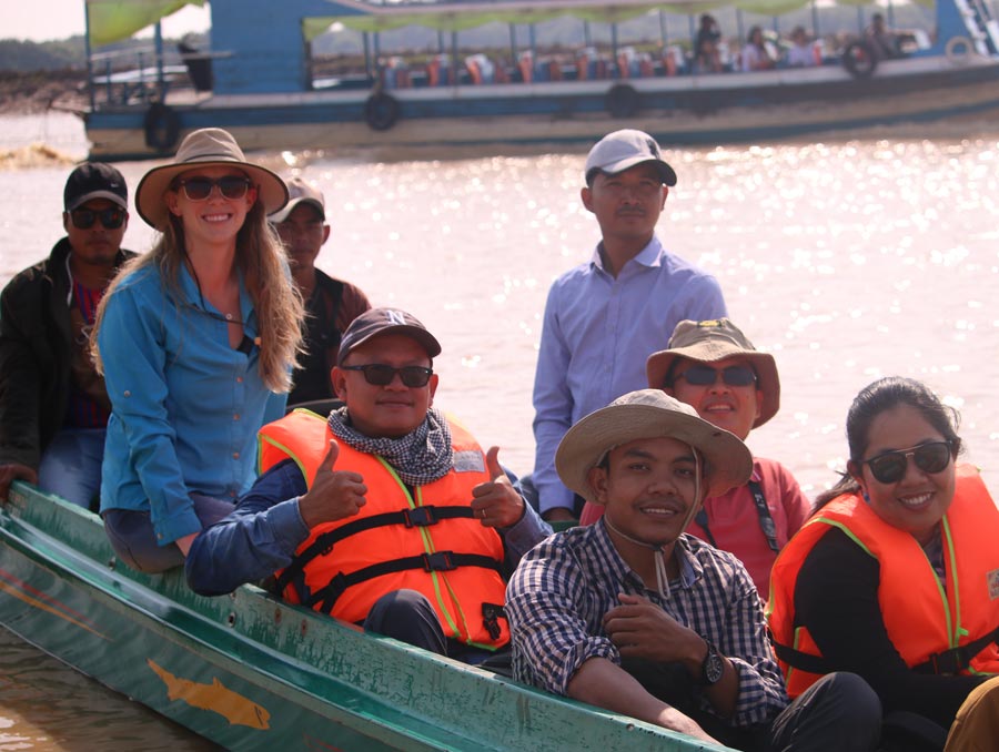 Elizabeth Everest dons a sun hat while on a boat in Cambodia with local Wonders of the Mekong team members.