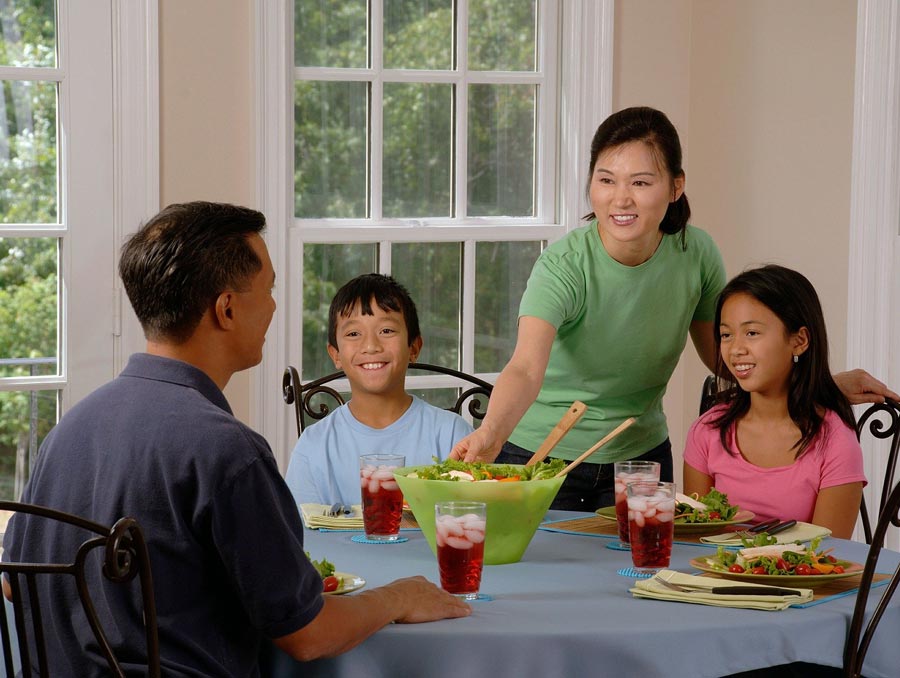 Asian family of four eating dinner at a table