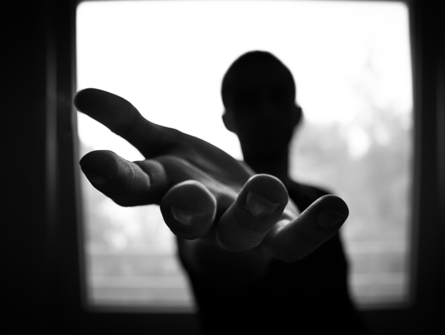 black-and-white image of person reaching out a helping hand toward the camera