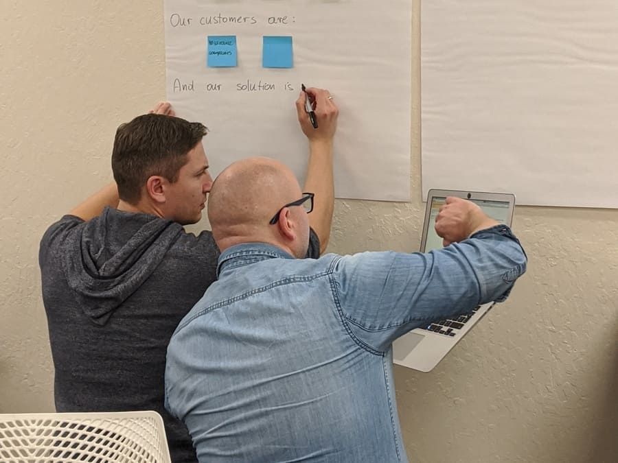 Two workshop participants developing content on flipchart paper