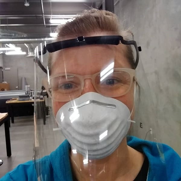 Nicole Miller models a face shield 3D printed in the Art Department Fabrication Lab.