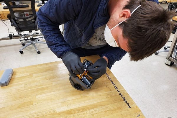 Michael Gillette completes a respirator battery pack 3D printed in the Innevation Center Makerspace.