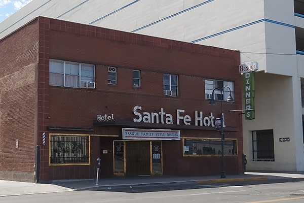 Single-story red brick building with "Santa Fe Hotel" neon signage on the exterior.