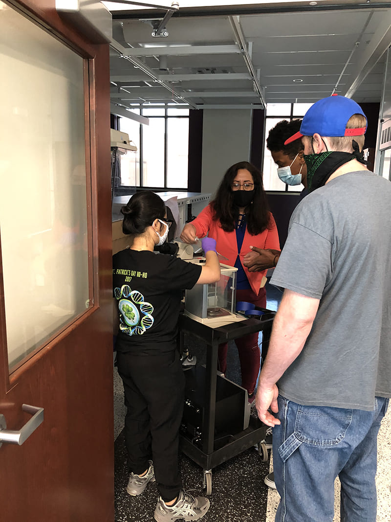 professor and students moving equipment into laboratory