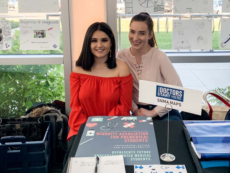 Two students pose for a photo at a club fair to promote the new MAPS club on campus last spring.