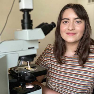 Sarah Trubovitz next to a microscope.