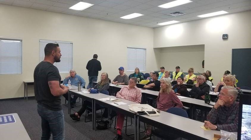 Austin Pollard standing in front of a group of people speaking