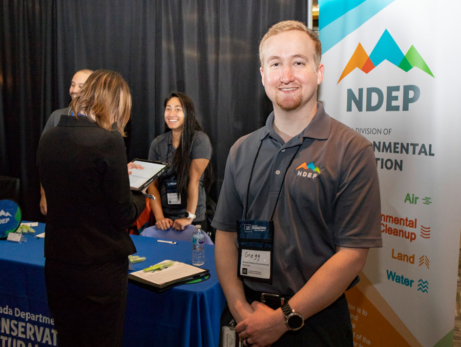 Gregg Rosenberg stands in front of a table at the career fair.