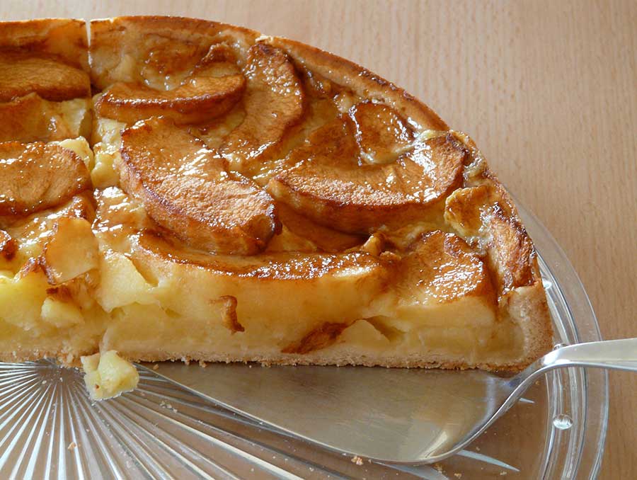 Apple pie on glass plate with serving utensil