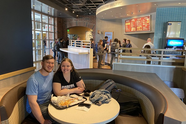 A couple sits in a booth with food at the Habit Burger Grill