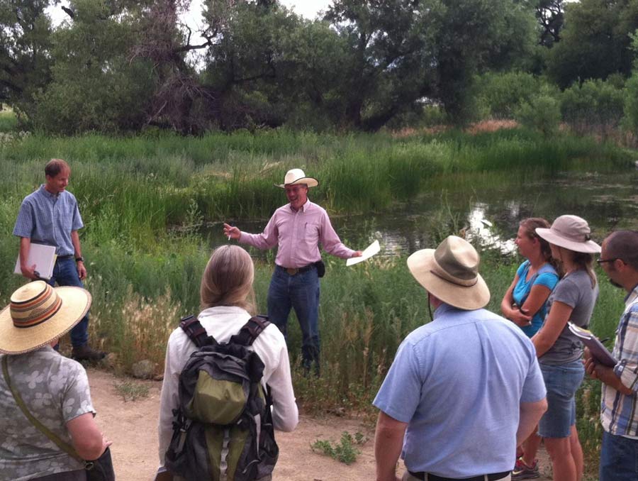 Sherm Swanson teaching a group of adults next to a pond