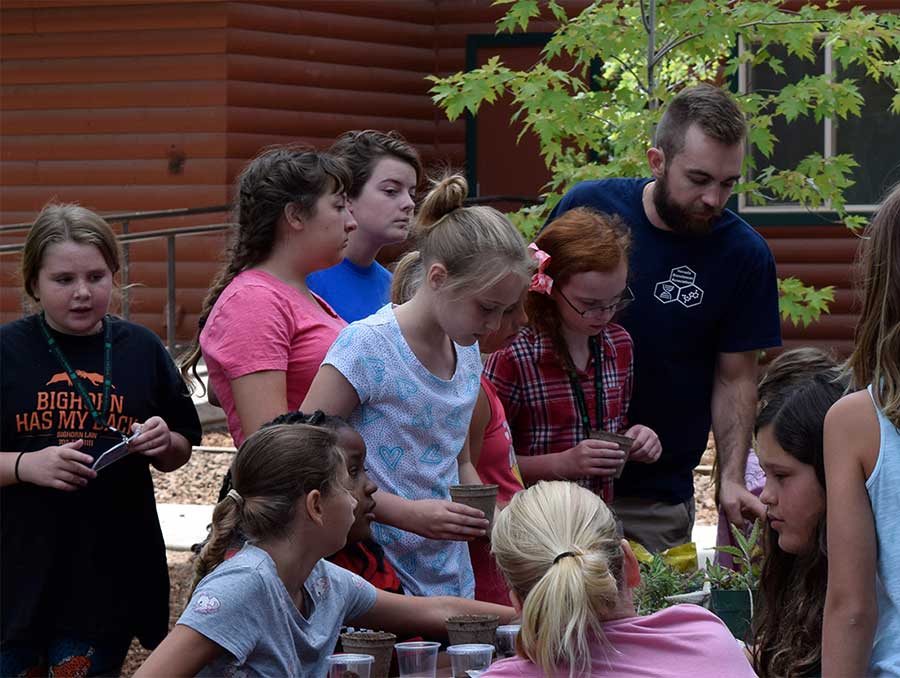 4-H campers doing an experiment on seedlings with graduate student