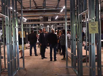 Donors and supporters visit with Eddy House employees during a “Wonderland on Willow Street” fundraising event, a building still under construction.