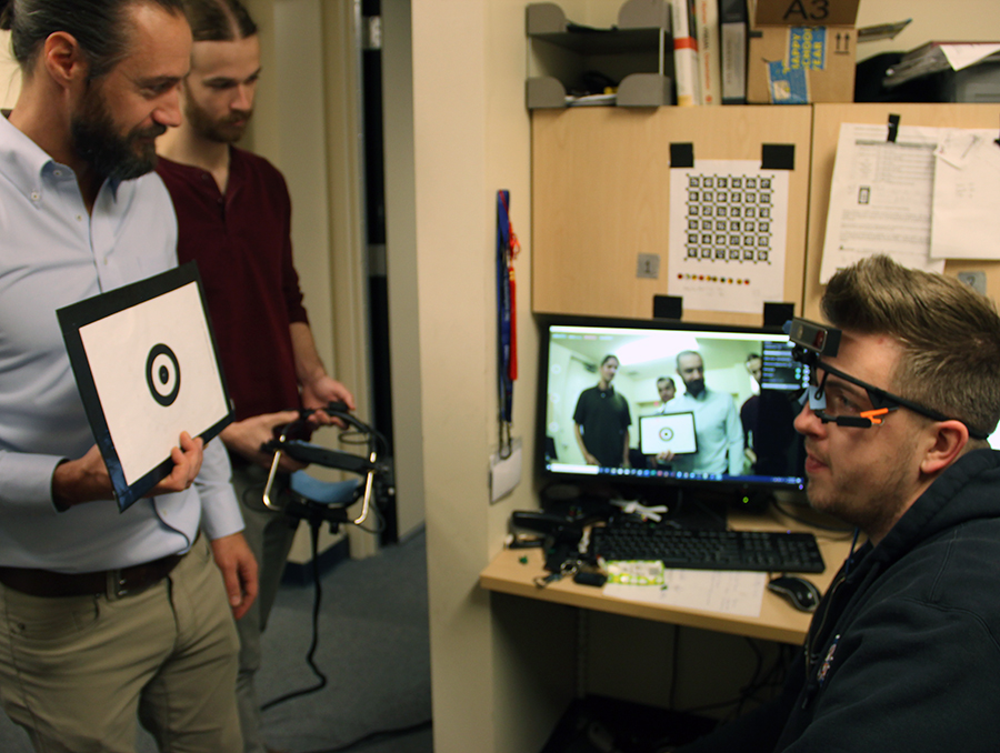 Assistant professor and students calibrate video headset