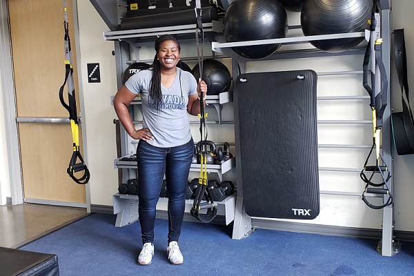 Sheena Harvey stands in front of on of the many "hidden gyms" at E.L. Wiegand Fitness Center