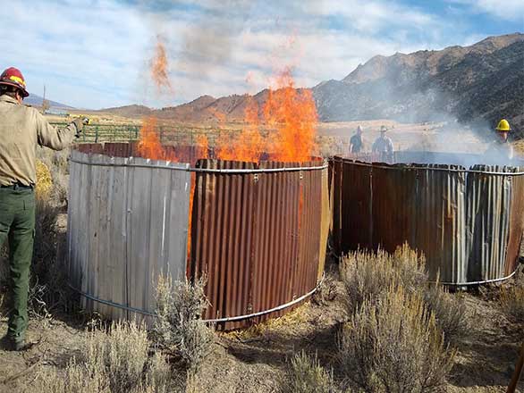 A burn barrel on fire on a range