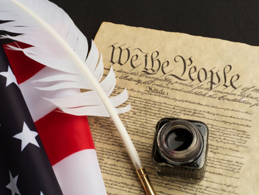 We the People document, American flag and quill pen