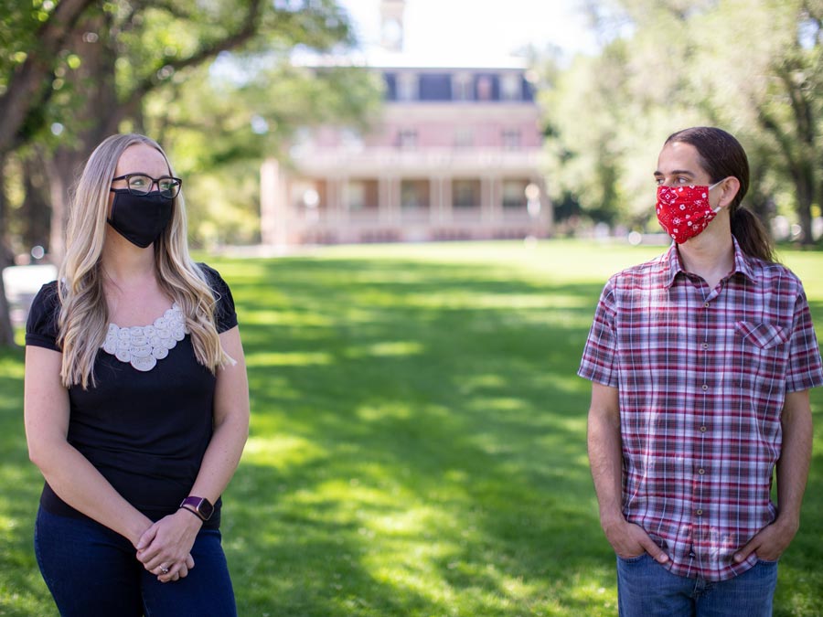 Kyra Morgan and Paul Hurtado stand on the quad wearing masks.