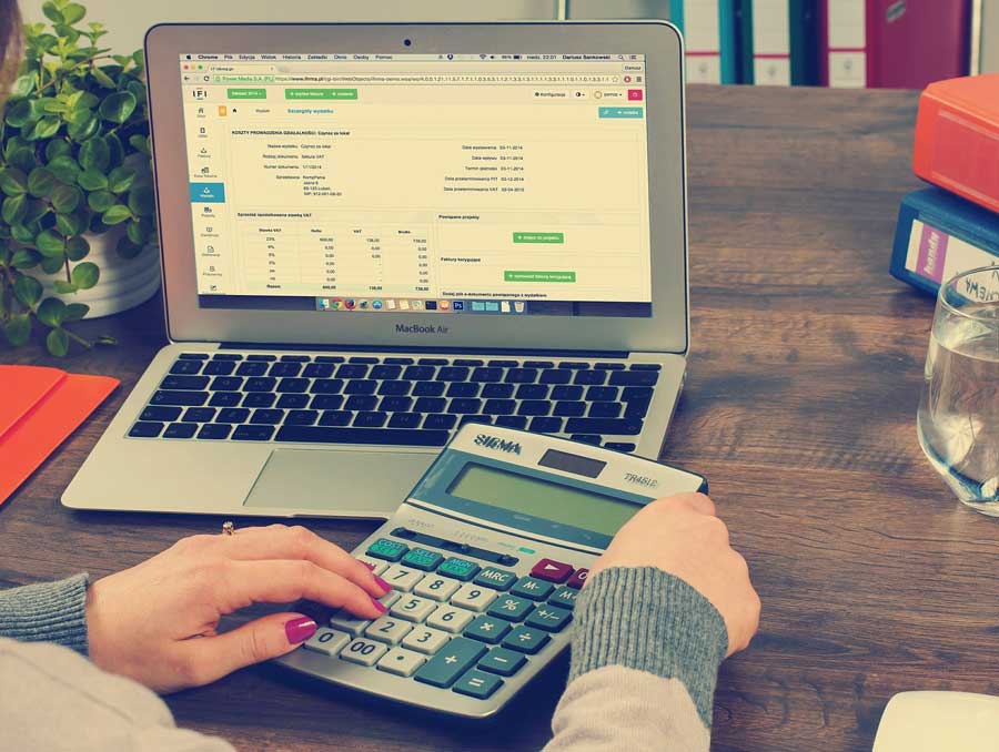 person using a laptop and calculator