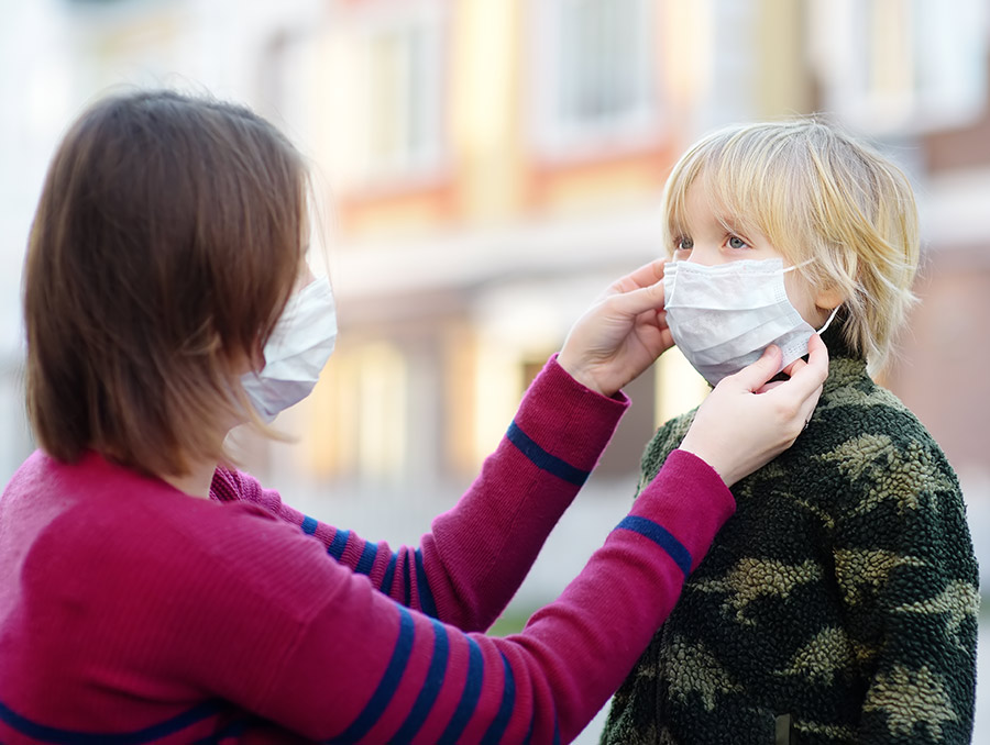 Mother putting mask on a child