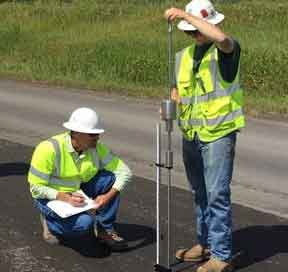 A photo of Forrest Hierholzer conducting measurements while Professor Adam Hand writes them down.