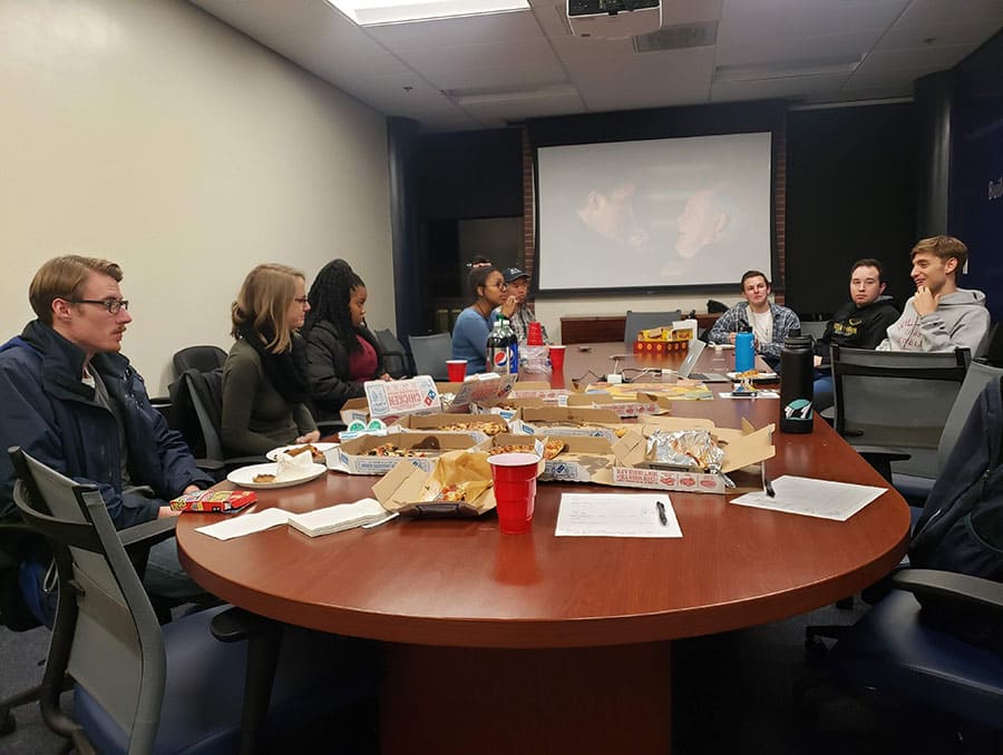 University Enactus club members planning project around table.