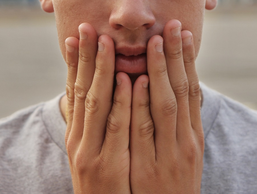 A person with both hands on their face