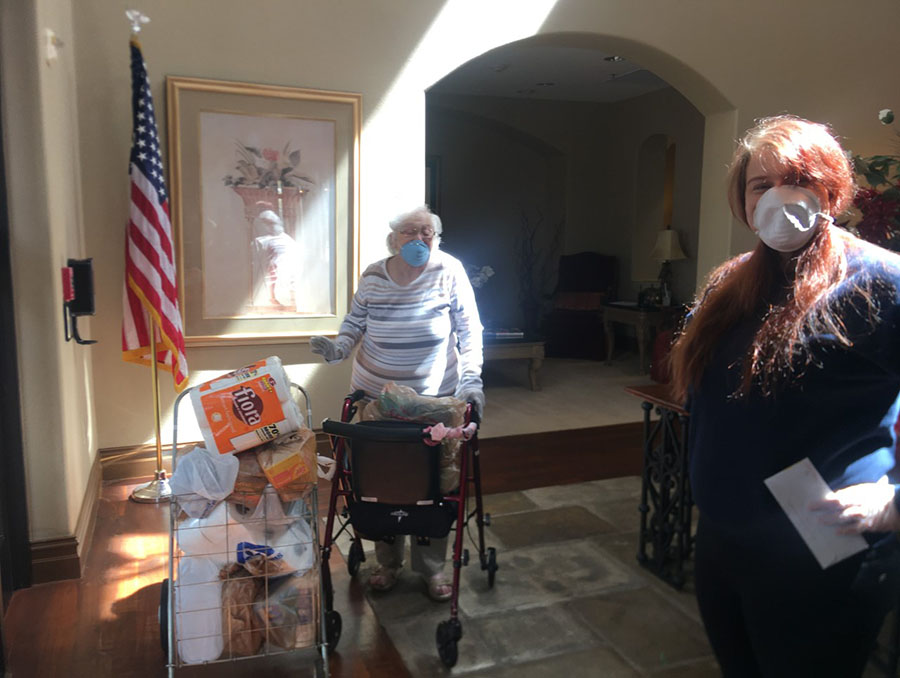 University of Nevada, Reno student Jayde Powell stands with a senior citizen client after delivering their groceries