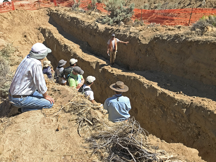 students studying earthquake trench