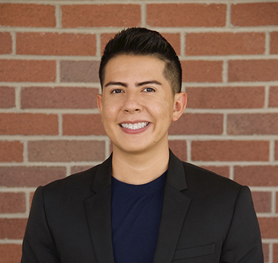 McNair Scholar Anthony Martinez pictured in front of a brick wall