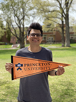 McNair Scholar Edward Cruz stands in the Quad at the University of Nevada, Reno holding a Princeton University flag