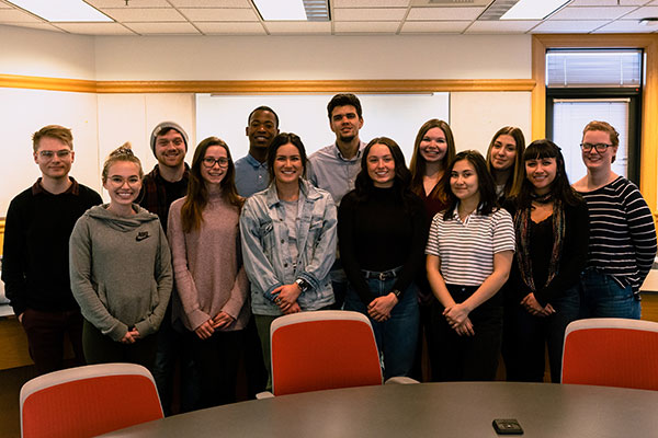 A large group of students pose in the Reynolds School. 