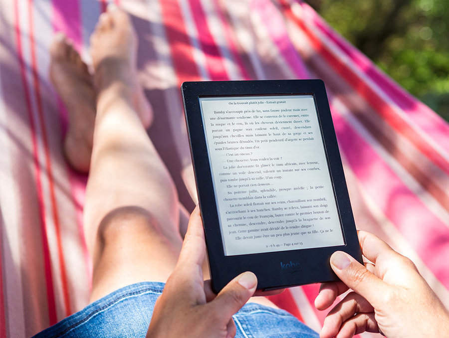 Woman laying in hammock reading a nondescript ebook on an ereader device