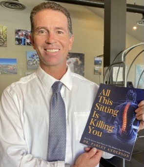 Dr. Anderson posing with his new book 