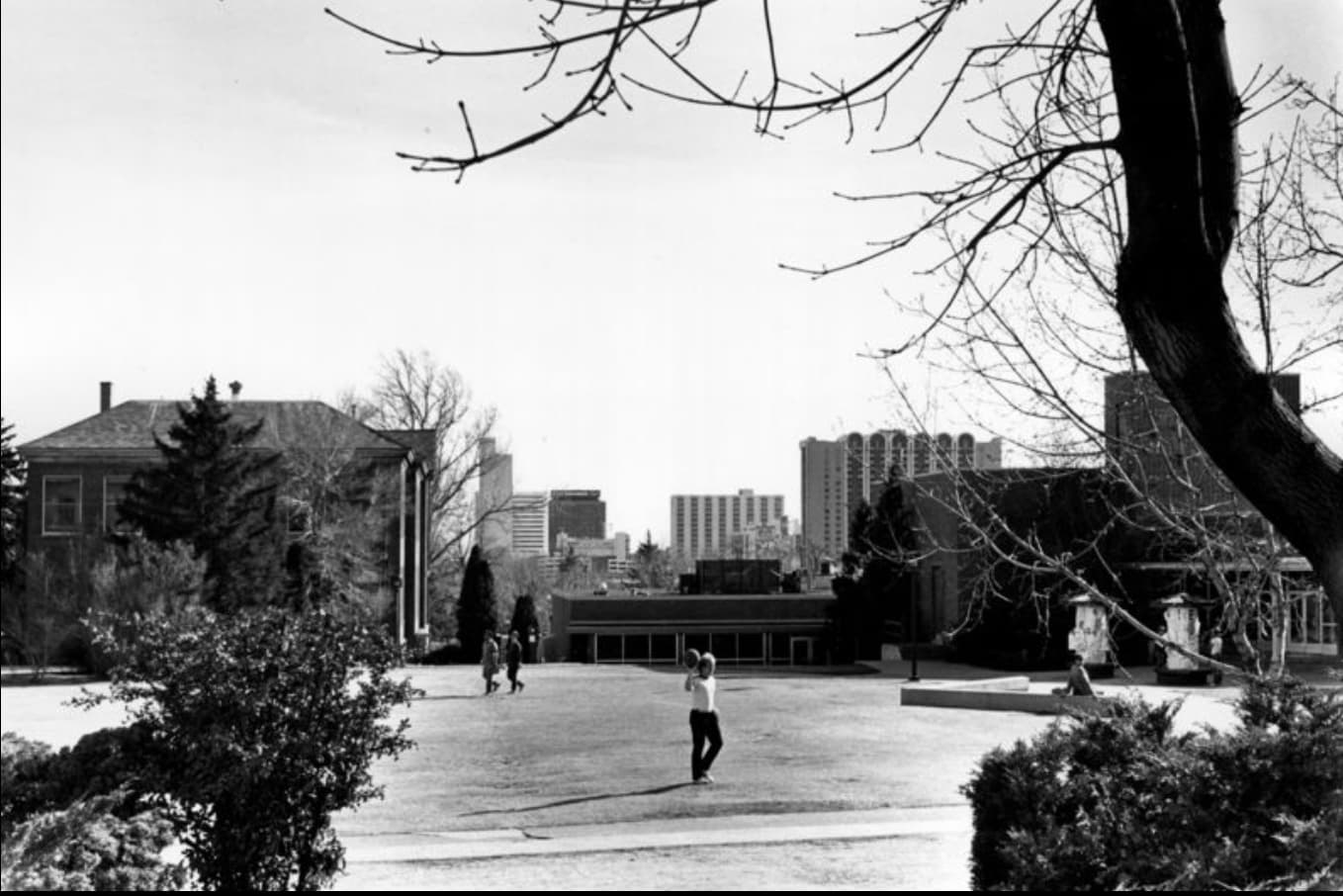 A student stands on the lawn in front of the Jot Travis while throwing a ball in 1985.