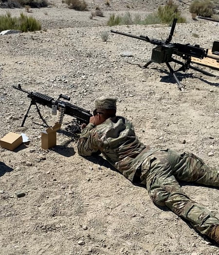 Michael Hanson in military clothing firing a machine gun 