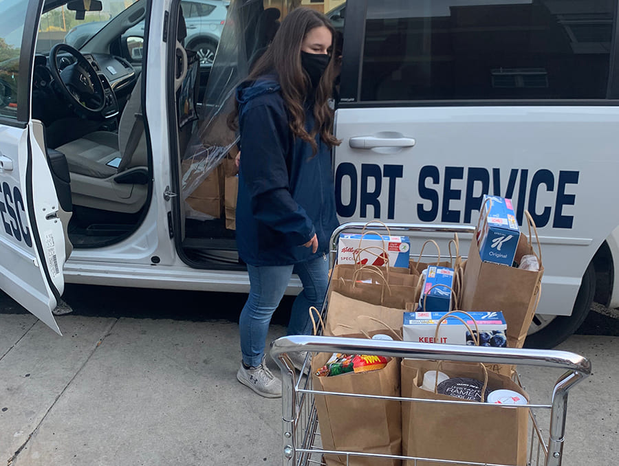 Student loading the Campus Escort van with items for delivery from Pack Provisions.