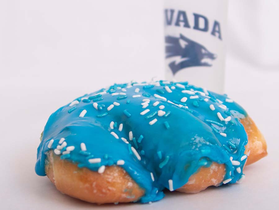 Blue Wolf Pack Paw donut with a white Nevada logoed water bottle.