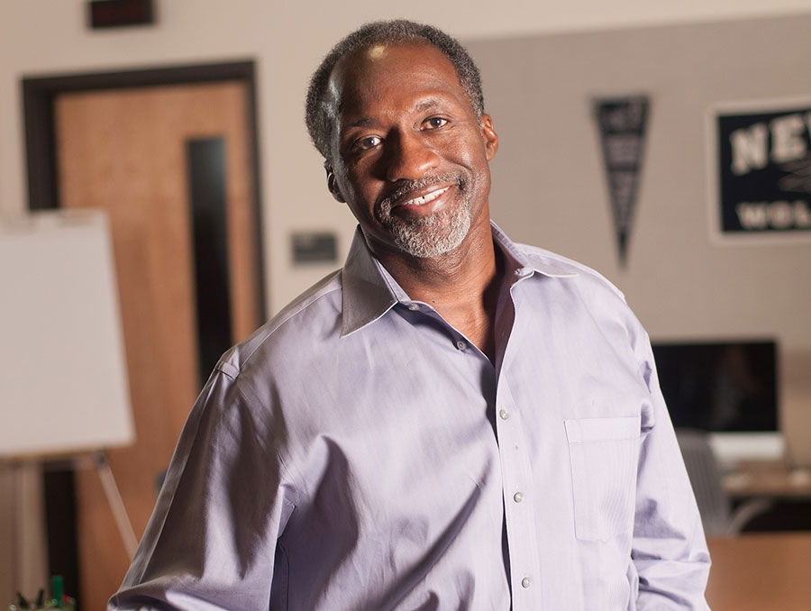 Caesar Andrews poses in a classroom