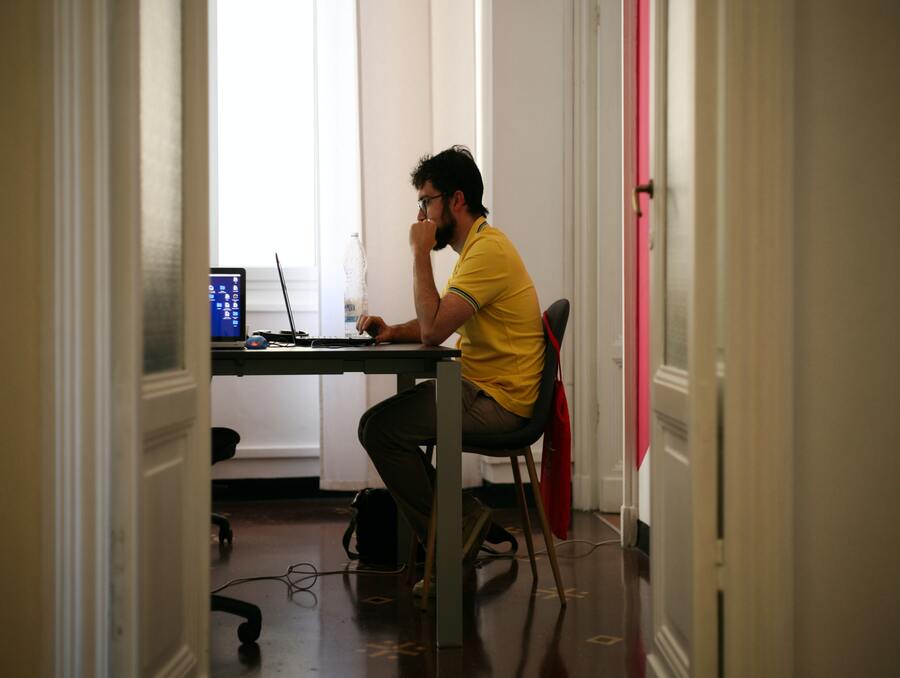 man sitting at a desk while on the computer 