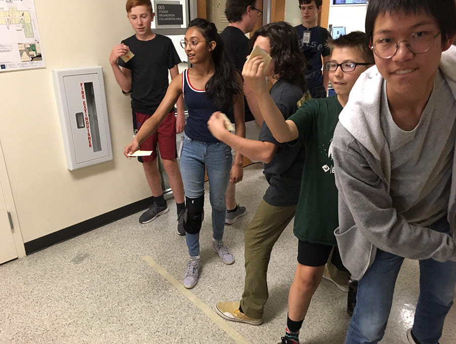 students in line in hallway preparing to throw items