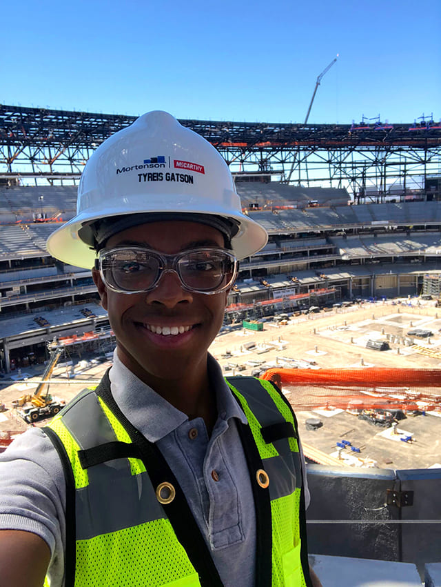 person in hard hat at stadium construction site